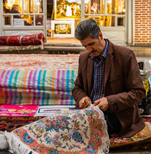 Tabriz, Iran-October 31, 2019: Hand woven rugs making in Grand Bazaar of Tabriz, the largest covered market in the world, in Tabriz, East Azerbaijan Province, Iran. UNESCO World Heritage.