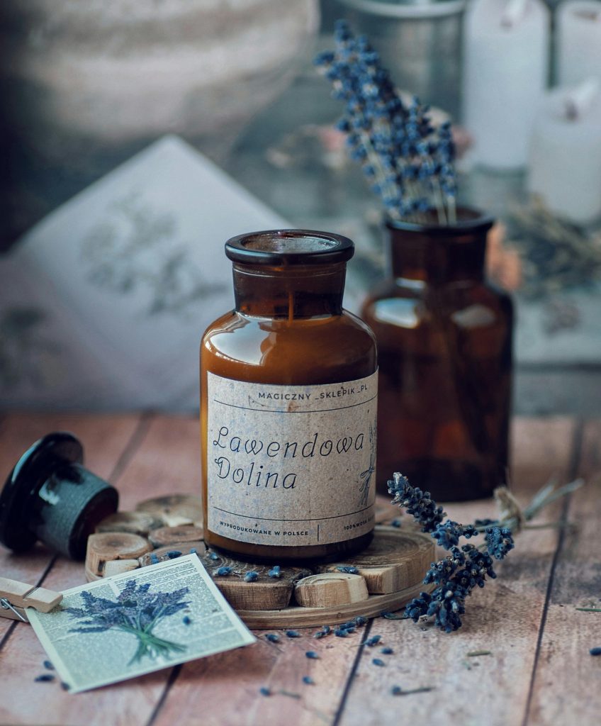 Stylish arrangement of glass bottles with lavender and rustic decor, ideal for aromatherapy themes.