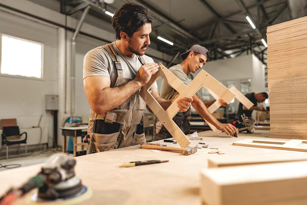 two-young-men-carpenters-making-furniture-warehouse-wood-factory_93675-150859